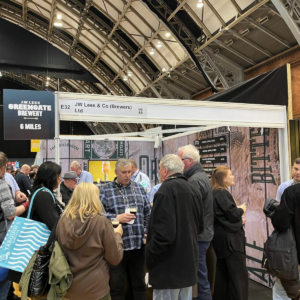 Attendees networking and sampling drinks at the JW Lees & Co (Brewers) stand during Northern Restaurant & Bar 2024