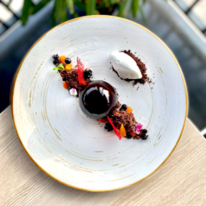 A luxurious chocolate dessert with vibrant fruit accents, reflecting the innovation and craftsmanship highlighted in The MICHELIN Guide Great Britain & Ireland 2025.